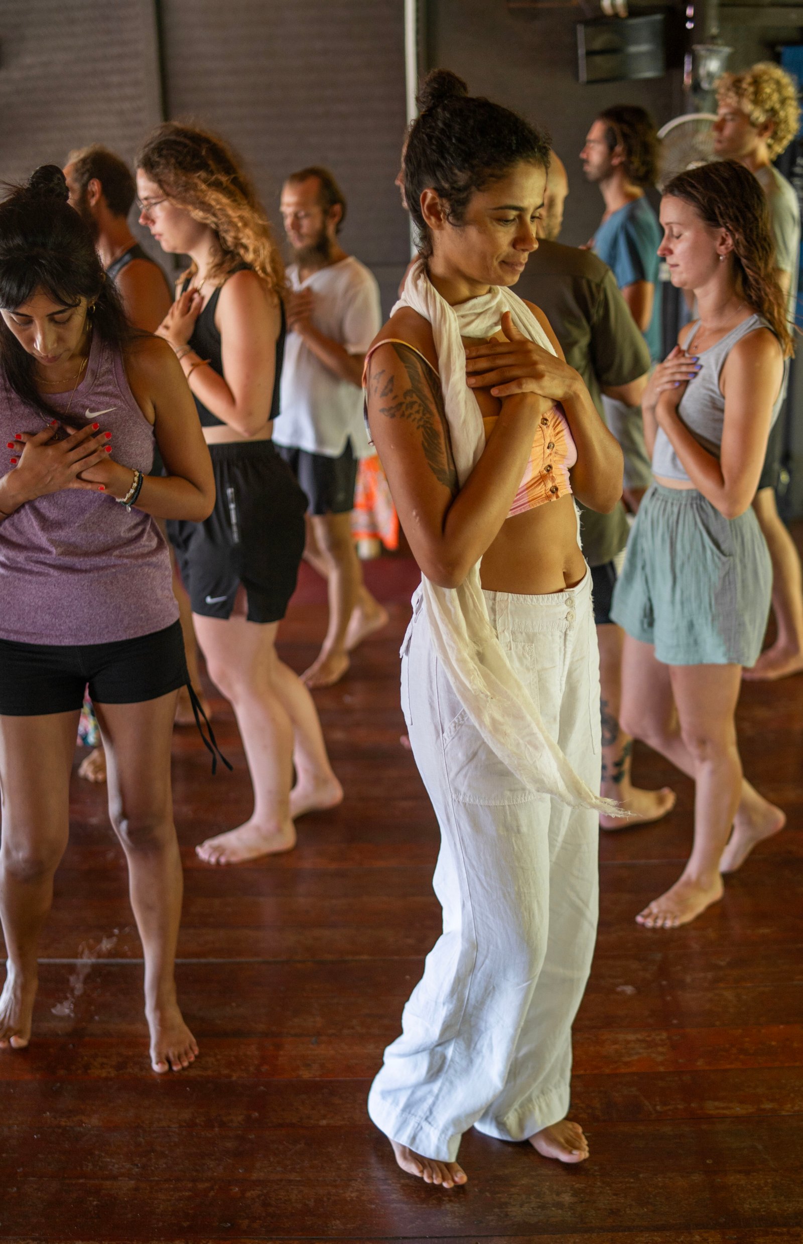 A person practicing tantra meditation with hands in a mudra, surrounded by soft candlelight.