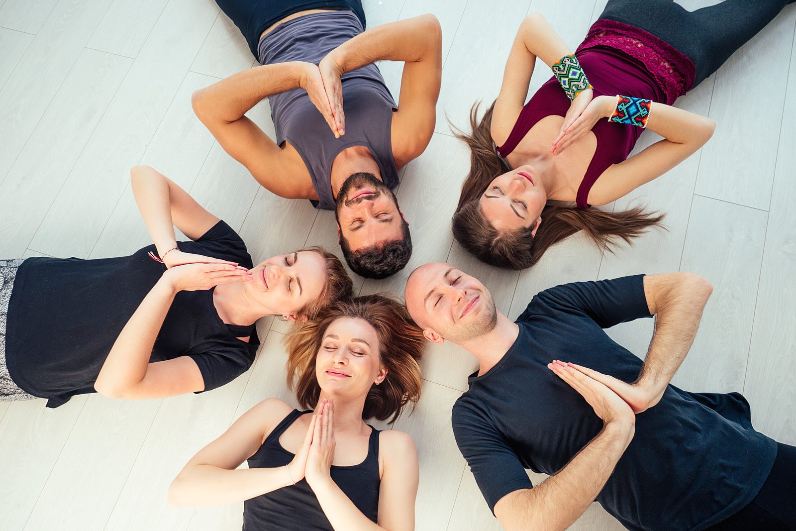 a happy group of people from men and women practicing yoga in the studio. groups of meditation , communication yoga class. the concept of group meditation and teamwork. coach and students in a circle